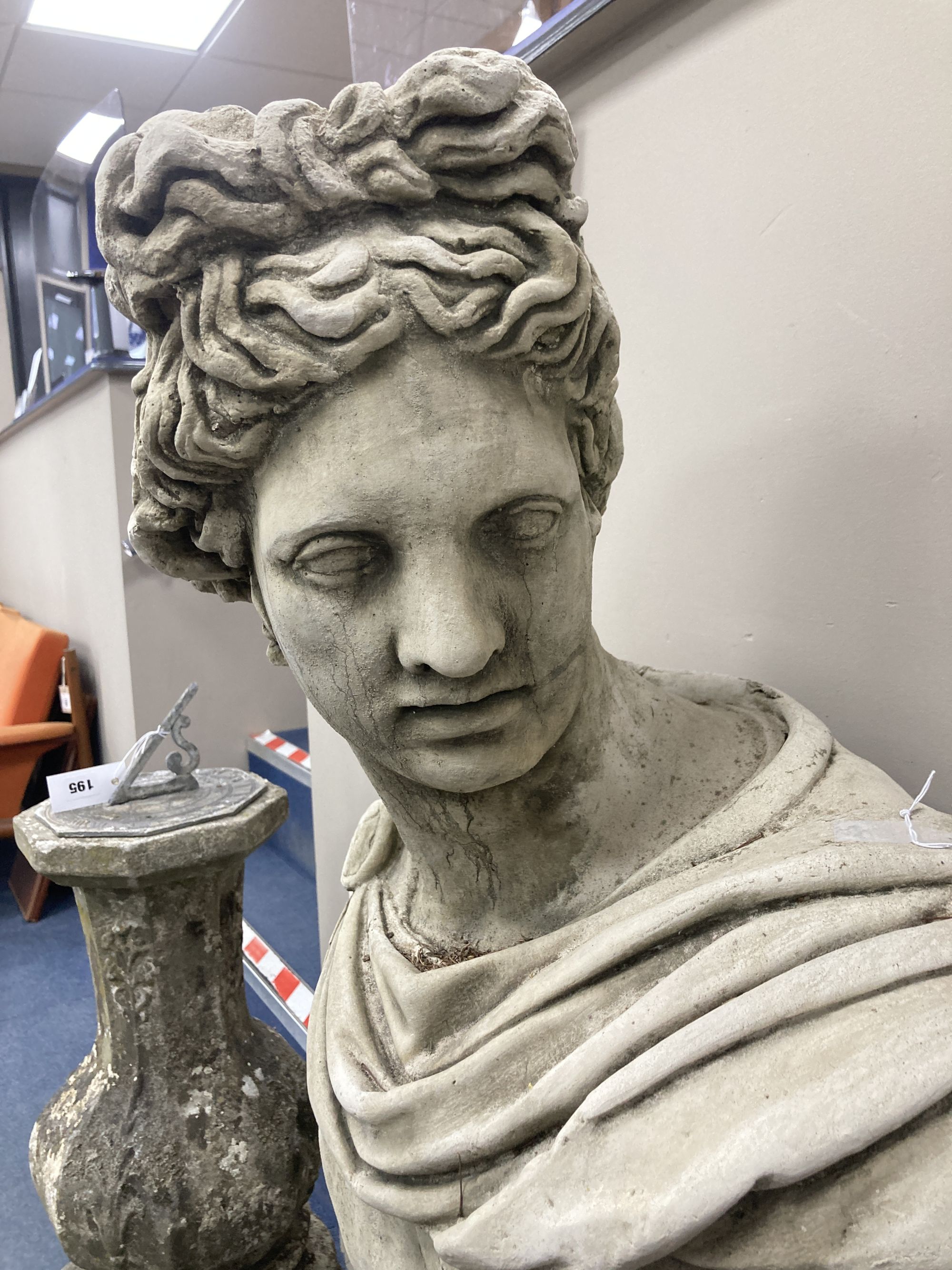 A reconstituted stone bust of a Roman Emperor, on a square plinth, height 122cm